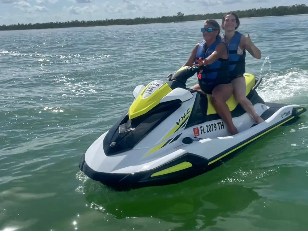 a person riding on the back of a boat on a body of water