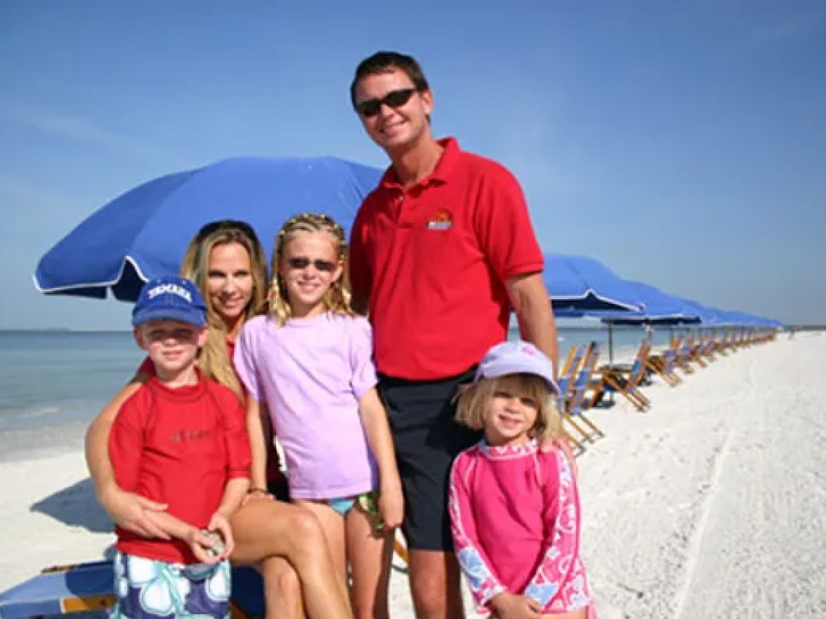 a group of people posing for photo on the beach