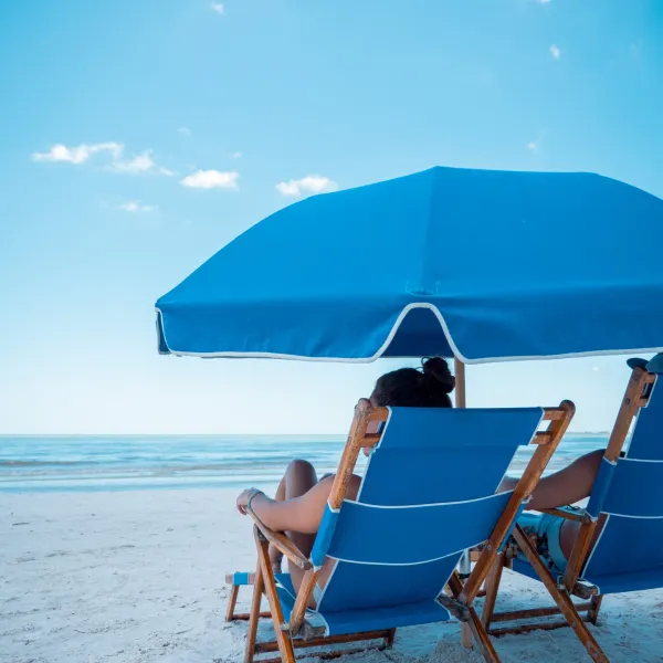 a blue umbrella sitting on top of a sandy beach