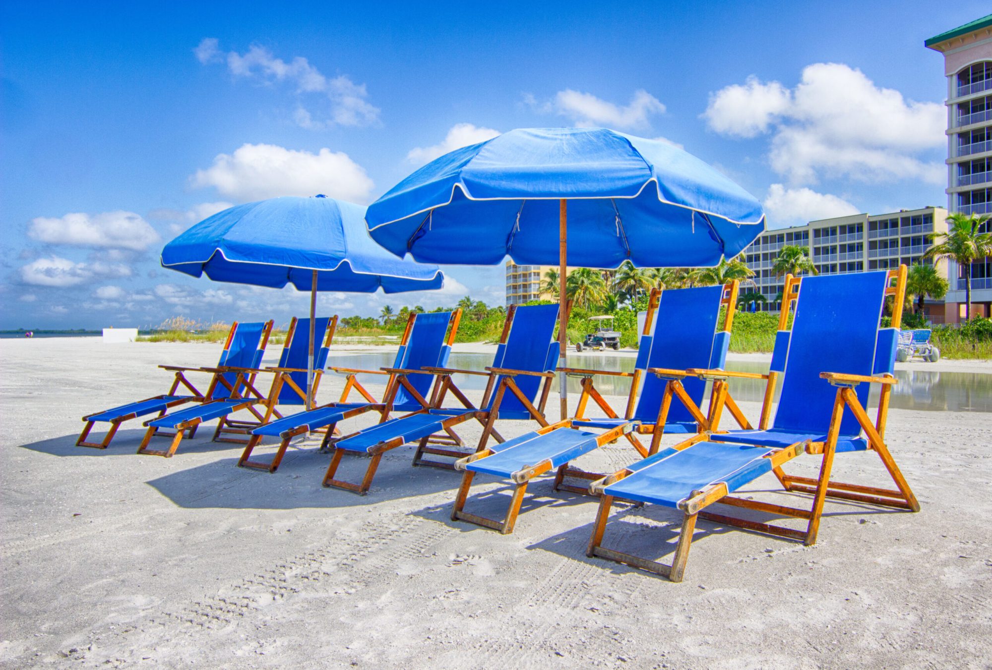 Beach chairs and umbrellas from Holiday Water Sports a group of beach chairs and umbrellas onf Fort Myers Beach