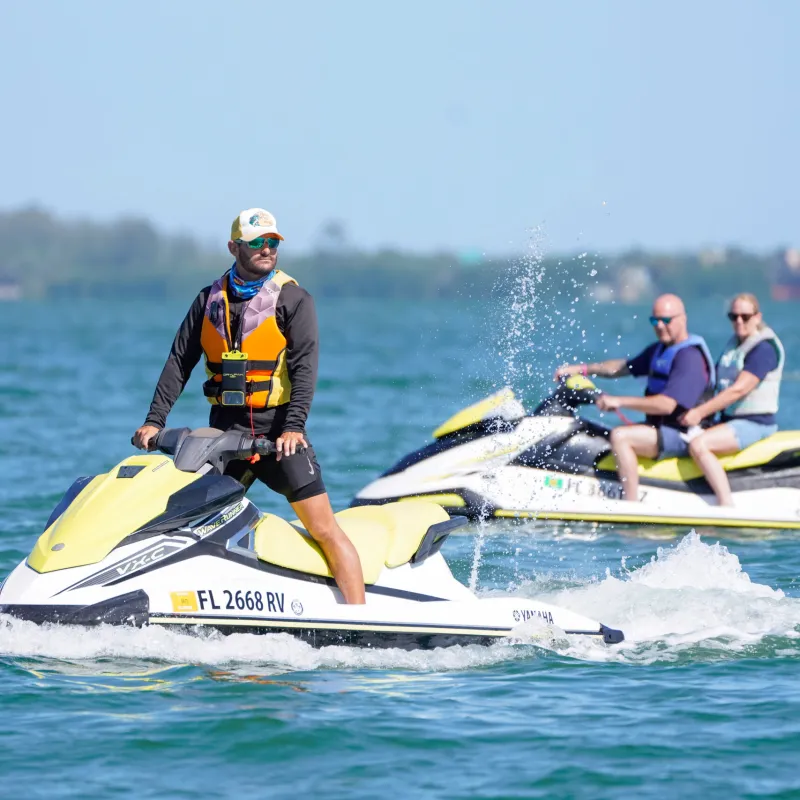a man riding on the back of a boat in the water