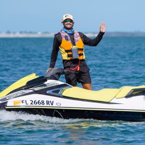 a man riding on the back of a boat in a body of water