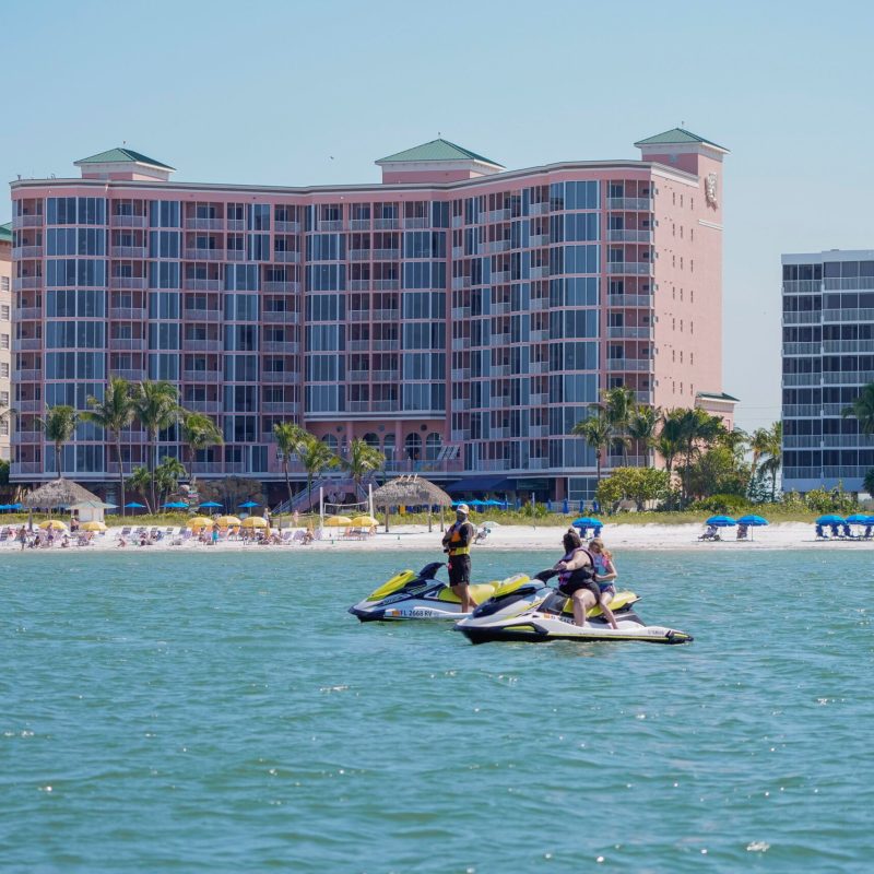 a small boat in a body of water with a building in the background