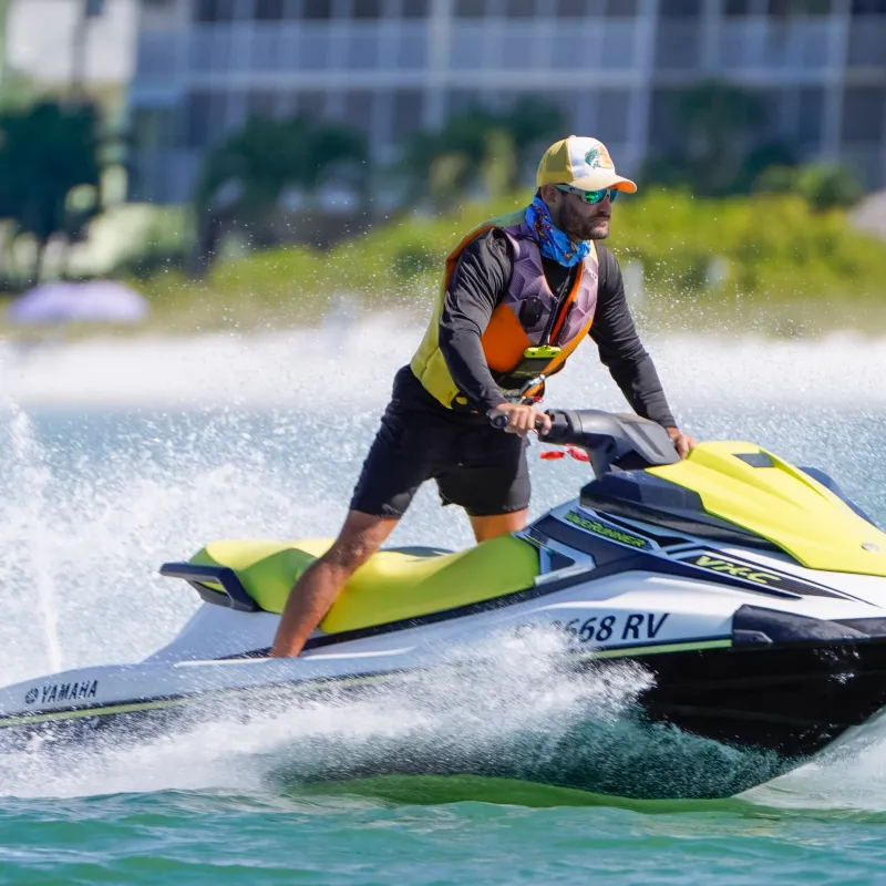 a man riding on the back of a boat in the water