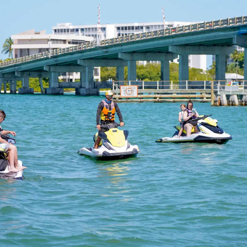 a group of people riding on the back of jetskis in the water