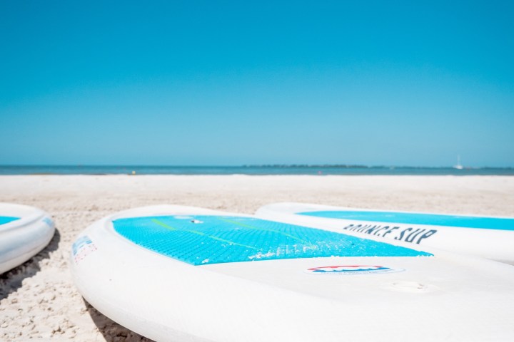 a beach with a surf board in the sand